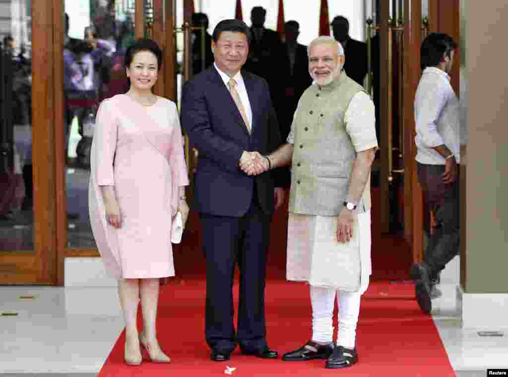 India's Prime Minister Narendra Modi (right) and China's President Xi Jinping shake hands as Xi's wife Peng Liyuan looks on before their meeting in the western Indian city of Ahmedabad, Sept. 17, 2014. 