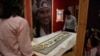 Co-curator Jo Loosemore, right, and Kate Johnson, Exhibitions Office Plymouth, prepare a recently created wampum belt made by members of the Wampanoag Native America people, to put on display in Southampton, England, Aug. 13, 2020. 