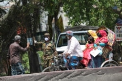 An army personnel stops people riding on a rickshaw at a check post during government imposed countrywide shutdown amid concerns over the coronavirus disease (COVID-19) outbreak in Narayanganj, Bangladesh, April 9, 2020.