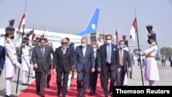 Abdul Razak Dawood, adviser to the prime minister of Pakistan on commerce and investment, walks with Abdullah Abdullah, head of Afghanistan's peace council, upon his arrival in Islamabad, Sept. 28, 2020.
