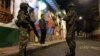 Seorang warga berbicara dengan dua tentara yang melakukan tugas patroli penerapan jam malam di Candelaria, Bogota, Jumat (22/11).