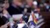 Bendera kecil yang melambangkan hak-hak kelompok LGBT tertata di sebuah meja di sisi anggota Partai Demokrat di DPR Kansas di Topeka, pada 28 Maret 2023. (Foto: AP/John Hanna)