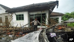 Polisi memeriksa kerusakan sebuah rumah warga Ahmadiyah setelah diserang oleh kelompok garis keras di Pandeglang, Banten. (Foto: Dok)