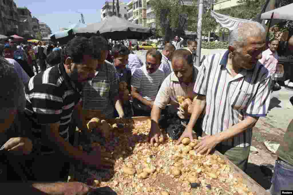 Warga membeli kentang dari penjual di pinggir jalan Karaj Al-Hajez, Aleppo, Suriah. 