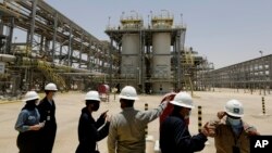 Insinyur dan jurnalis Saudi Aramco melihat proyek gas Hawiyah di Hawiyah, di Provinsi Timur Arab Saudi pada 28 Juni 2021. (Foto: AP)