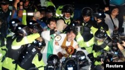 People scuffle with riot police during a protest opposing the deployment of a Terminal High Altitude Area Defense (THAAD) system in Seongju, South Korea, Sept. 7, 2017.