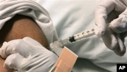 FILE - Patient is given injection for pain relief by nurse at the Sickle Cell Center, Truman Medical Center, Kansas City, Missouri.