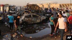 Orang-orang berkumpul di lokasi bom mobil di daerah Habibiya, Sadr City, Baghdad, Irak, 15 Agustus 2015. 