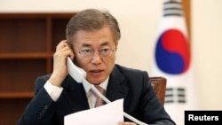 South Korean President Moon Jae-in speaks with Chinese President Xi Jinping by telephone at the Presidential Blue House in Seoul, South Korea, May 11, 2017.