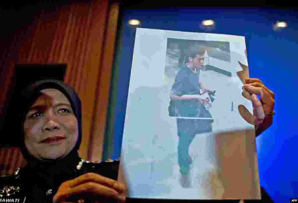 A Malaysian police official displays a photograph of 19-year-old Iranian Pouri Nourmohammadi, one of the two men who boarded missing Malaysia Airlines MH370 flight using stolen European passports.