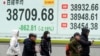 People walk in front of an electronic stock board showing Japan's Nikkei index at a securities firm, Feb. 3, 2025, in Tokyo.