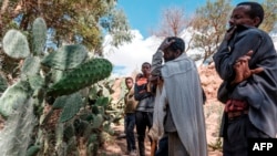 File - People mourn in front of a mass grave the victims of a massacre allegedly perpetrated by neighbouring Eritrean Soldiers in the village of Dengolat, North of Mekele, the capital of Tigray on February 26, 2021.