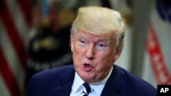 FILE - President Donald Trump speaks about sanctuary cities with law enforcement officers in the Roosevelt Room of the White House, in Washington, March 20, 2018. On April 12, 2019, Trump said he was considering sending detained illegal migrants to sanctuary cities.