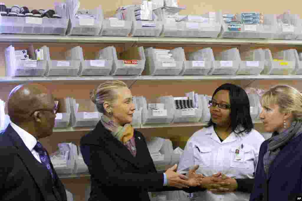South Africa's Health Minister Aaron Motsoaledi, left, and Hillary Clinton visit the Delft South Clinic in Delft South, a suburb of Cape Town, South Africa, August 8, 2012.