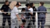 Ever Castillo, left, and his family, immigrants from Honduras, are escorted back across the border by U.S. Customs and Border Patrol agents, June 21, 2018, in Hildalgo, Texas. The parents were told they would be separated from their children.