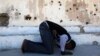 FILE - Somali athlete Abdullah Bare Kuulow prays after a training session in preparation for the 2012 London Olympic Games inside Mogadishu Stadium, March 16, 2012. AFRICOM troops have relocated from the complex, returning its main focus to athletics.