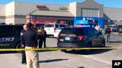 Law enforcement work the scene where two men and a woman were fatally shot, Nov. 18, 2019, outside a Walmart store in Duncan, Oklahoma. 