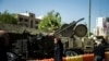 FILE - A man takes a selfie in front of an anti-aircraft weapon on display at Baharestan Square in Tehran, Iran Sept. 27, 2017. 