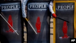 Demonstran antikudeta memegang perisai darurat selama protes di Yangon, Myanmar, 9 Maret 2021. (Foto: AP)