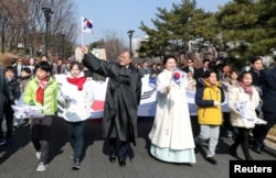 Presiden Korea Selatan Moon Jae-in dan istrinya Kim Jung-Sook melakukan pawai dengan berjalan bersama para peserta dalam upacara peringatan HUT ke-99 Gerakan Kemerdekaan Satu Maret melawan penjajahan Jepang di Seoul, Korea Selatan, 1 Maret 2018.