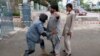 An Afghan policeman frisks a man at a polling station in Jalalabad, east of Kabul, Afghanistan, April 5, 2014