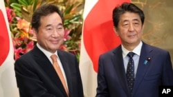 Perdana Menteri Korea Selatan Lee Nak-yon, kiri, berfoto bersama dengan Perdana Menteri Jepang Shinzo Abe sebelum pertemuan mereka di kediaman resmi Abe di Tokyo, Kamis, 24 Oktober 2019. (Foto: AP/Koji Sasahara)
