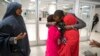 FILE - Ismail Issack, father of Miski Shalle, 11, and Muzamil Shalle, 14, embraces his children as their mother Halima Mohamed, far left, looks on as they reunite for the first time in seven years at John F. Kennedy International Airport in New York.