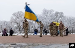 Rekan prajurit membawa peti jenazah aktor utama teater musikal dan drama Petro Velykiy, 48 tahun, di Chernyhiv, Ukraina, Rabu, 27 November 2024, yang tewas dalam pertempuran dengan pasukan Rusia di wilayah Kursk Rusia. (Dan Bashakov/AP)