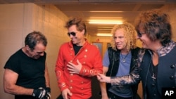 Dari kiri Tico Torres, Jon Bon Jovi, David Bryan, dan Richie Sambora dari band rock AS Bon Jovi bergurau di belakang panggung di Munich, 12 Juni, 2011