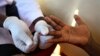 FILE - A doctor draws blood to check for HIV/AIDS in a Kampala, Uganda, suburb, May 16, 2014. A Ugandan law enacted in 2014 criminalizes HIV transmission, attempted transmission, and behavior that might lead to transmission by those aware of their HIV status.