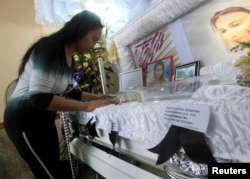 A woman pays her respects to slain transgender Jennifer Laude inside a funeral home in Olongapo city, north of Manila October 21, 2014. Philippine President Benigno Aquino rejected on Monday calls to tear up the Visiting Forces Agreement with the United S