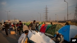 Volunteers put up tents for protesting farmers in the middle of a major highway which is blocked in a protest against new farm laws at the Delhi-Uttar Pradesh state border, India, Dec. 25, 2020.