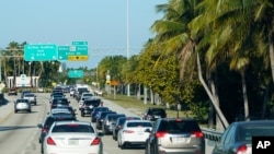 FILE - Cars slow down after crossing a causeway to Miami Beach, Florida, May 28, 2021.
