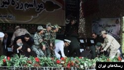 لحظاتی بعد از حمله به رژه نظامی منطقۀ اهواز، مقامات در جایگاه ویژه تلاش دارند از ساحه فرار کنند. روحانی سمت چپ، محمدعلی موسوی جزایری نماینده خامنه‌ای است