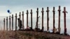 Seorang wanita berdiri di antara salib yang dipasang di sebuah bukit di atas SMA Columbine di Littleton, Colorado, untuk mengenang mereka yang tewas dalam penembakan di sekolah pada tanggal 20 April 1999 (AP)