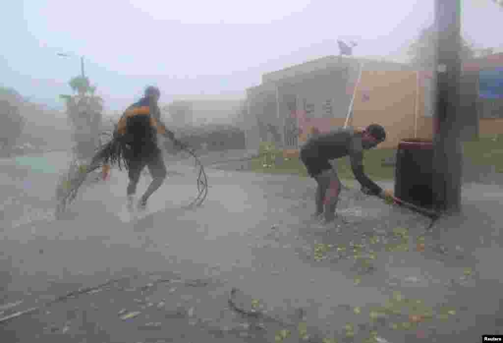 People pick up debris as Hurricane Irma howls past Puerto Rico after thrashing several smaller Caribbean islands, in Fajardo, Puerto Rico, Sept. 6, 2017.