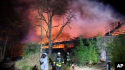 Firefighters stand in front of the burning monkey house at Krefeld Zoo, in Krefeld, Germnay, Wednesday Jan 1, 2020. A fire at a zoo in western Germany killed a large number of animals in the early hours of the new year, authorities said. (Alexander…