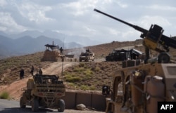 FILE - U.S. forces from NATO and Afghan commando forces are seen in a checkpoint during a patrol against Islamic State militants at the Deh Bala district in the eastern province of Nangarhar province, July 7, 2018.