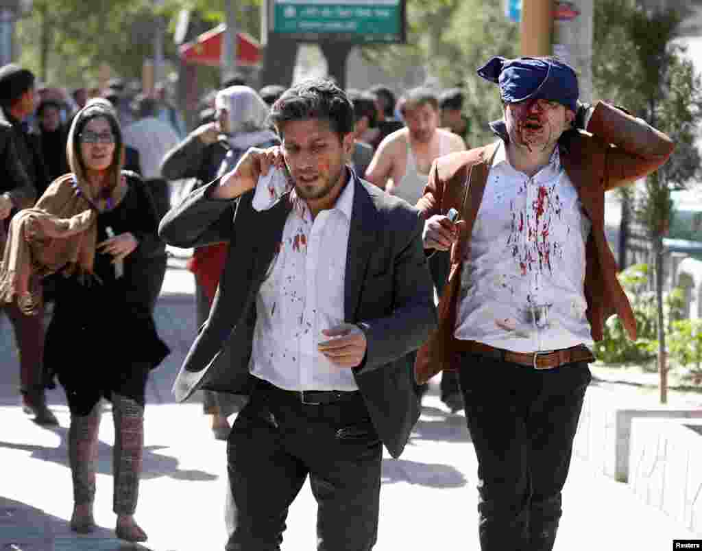 Injured Afghans run from the site of a blast in Kabul, Afghanistan May 31, 2017.