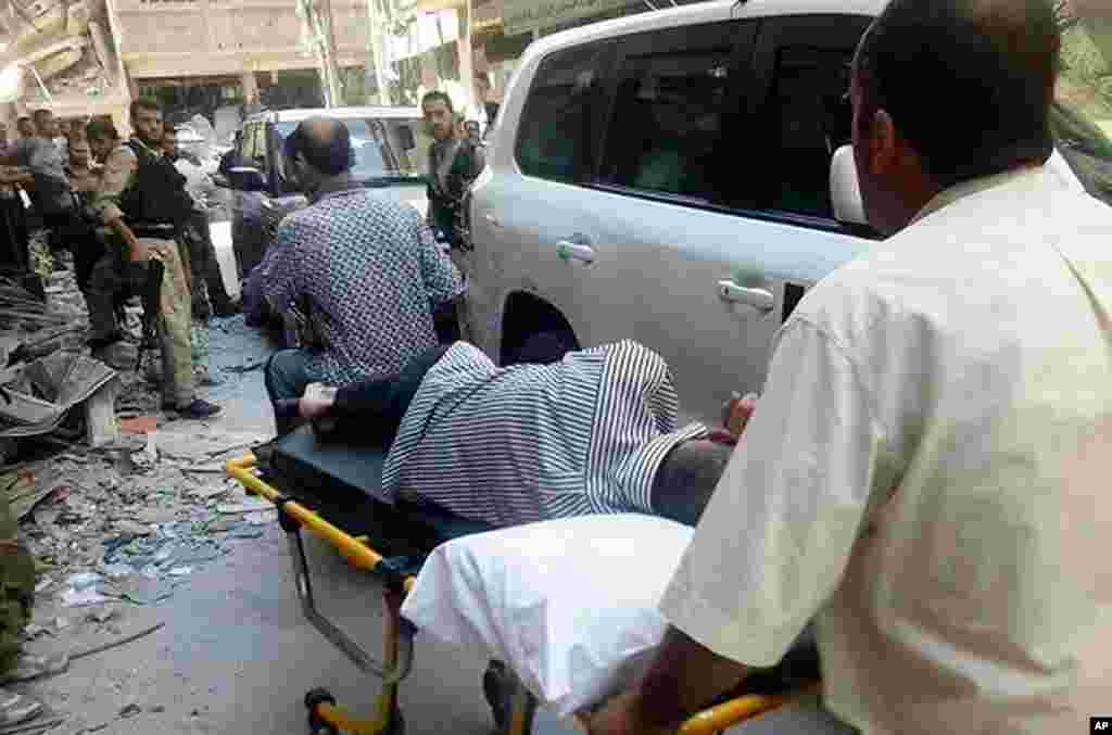 This citizen journalism image provided by the United media office of Arbeen shows Syrians moving a man who was allegedly exposed to chemical weapons to show him to U.N. investigators in a Damascus suburb, August 28, 2013.