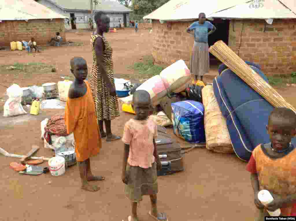 New arrivals from South Sudan stand next to their few possessions -- a jerry can, mattresses, suitcases, a machete and a pair of flip-flops -- in Kiryandongo settlement in northern Uganda.