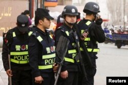 FILE - Armed police keep watch in a street in Kashgar, Xinjiang Uighur Autonomous Region, China, March 24, 2017.
