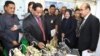 Attendees at the 3R Forum look at toy motorcycles made from recycled parts, Surabaya, Indonesia. (Petrus Riski/VOA)