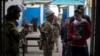 An Egyptian army soldier stands guards as people line up to vote in the country's constitutional referendum in Cairo, Egypt, Jan. 14, 2014. 