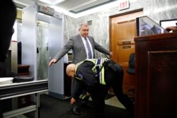Lev Parnas, a Rudy Giuliani associate with ties to Ukraine, has his ankle bracelet checked by a member of the U.S. Capitol Police on Capitol Hill in Washington, Jan. 29, 2020.