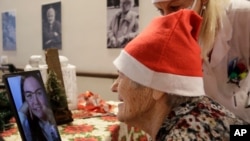 Caterina Bertocchi, 91, talks via video call with Irene Schiavone, a donor unrelated to her, who bought and sent her a Christmas present through an organization dubbed ‘Santa's Grandchildren’, at the Martino Zanchi nursing home in Alzano Lombardo, Italy,