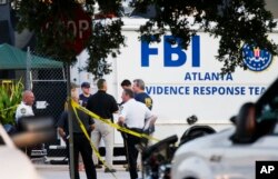 Law enforcement officials gather outside the Pulse nightclub, the scene of Sunday's mass shooting, June 15, 2016, in Orlando, Fla.