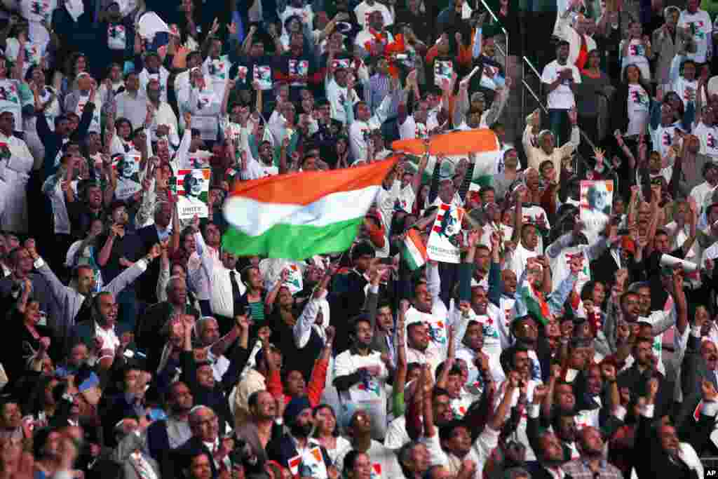 Supporters cheer and wave Indian flags as Indian Prime Minister Narendra Modi gives a speech during a reception by the Indian community in honor of his visit to the United States, Madison Square Garden, New York, Sept. 28, 2014.