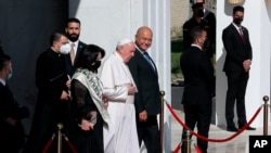 Pope Francis, center, walks with Iraqi President Barham Salih towards his plane upon concluding his visit to Iraq at Baghdad airport, Iraq, Monday, March 8, 2021. Pope Francis left Baghdad on Monday after three days of the historic whirlwind tour of…