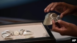 Isaac Levy, owner of Israeli jewelry company Yvel holds parts of a mask in Motza near Jerusalem, Sunday, Aug. 9, 2020. An Israeli jewelry company is working on what it says will be the world's most expensive coronavirus mask, a gold, diamond…